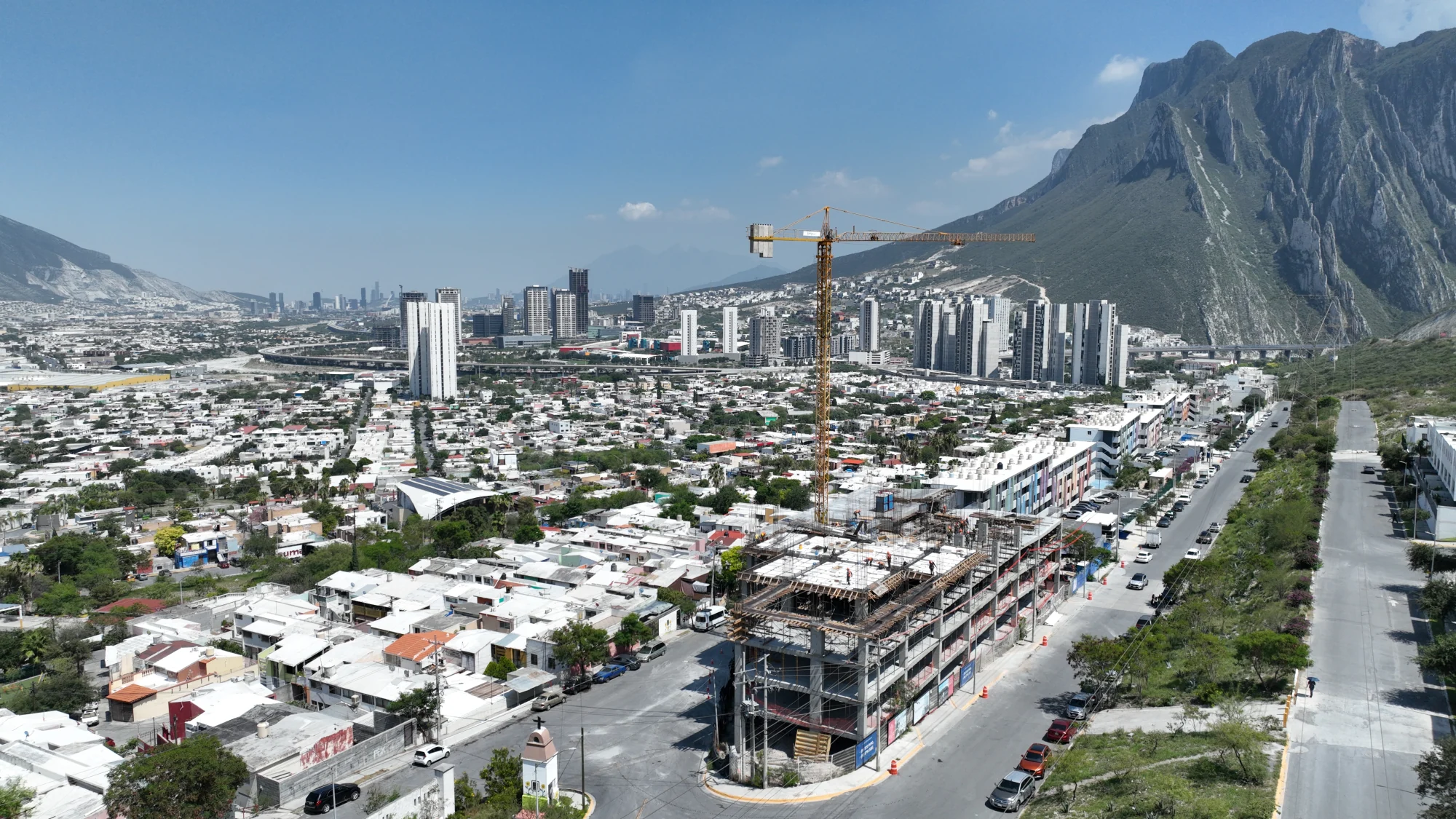 Estructura en construcción de Porta Huasteca con grúa y montañas al fondo en 2025